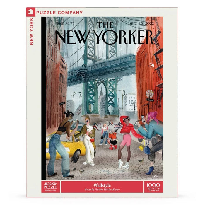 A 1000-piece jigsaw puzzle box of a The New Yorker cover, featuring a colorful illustration of a city street scene with pedestrians, a yellow cab, and a bridge in the background. The front of the box is shown on a clean white background.