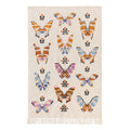 Beige tea towel with colorful butterfly pattern and fringes on a white background.