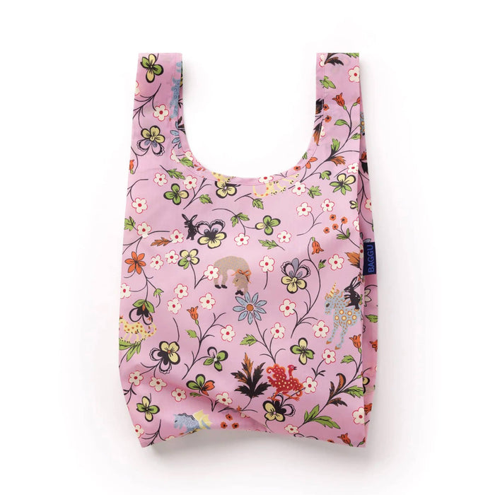 A reusable pink shopping bag with a dense, colorful floral and nature print featuring flowers and mythical creatures, shown against a plain white background.