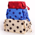 Three reusable zippered pouches stacked on top of each other, featuring a red one with red polka dots, a blue one with dark blue polka dots, and a cream one with black polka dots. The pouches are shown on a clean white background.