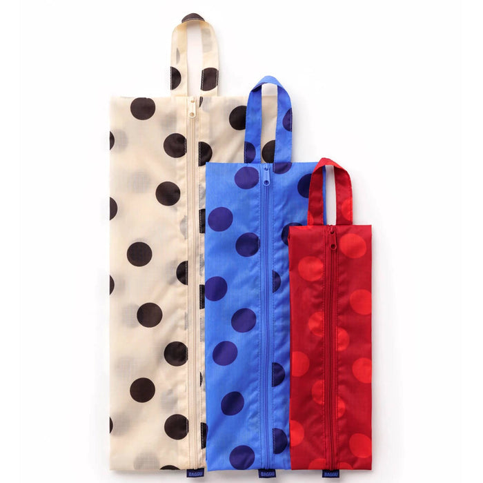Three zippered reusable pouches with large polka dots, shown vertically in cream, blue, and red on a plain white background.