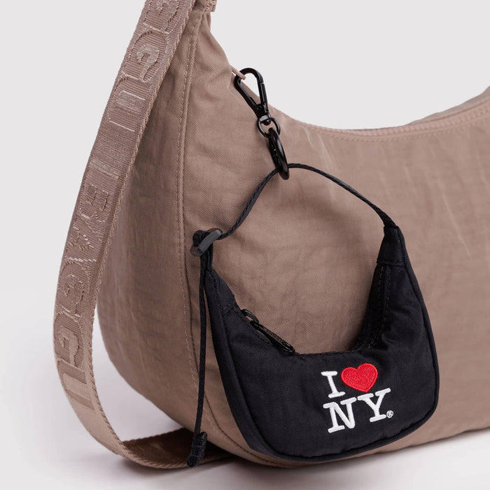 Brown shoulder bag with a black mini bag charm featuring 'I ❤️ NY', on a white background.