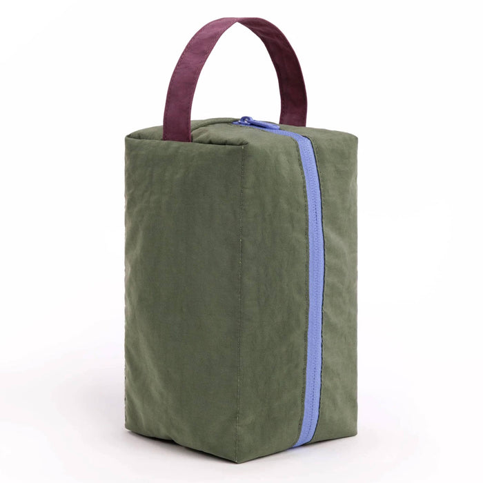 A caper green insulated lunch bag with a dark plum top handle, and a light blue zipper, on a white background.