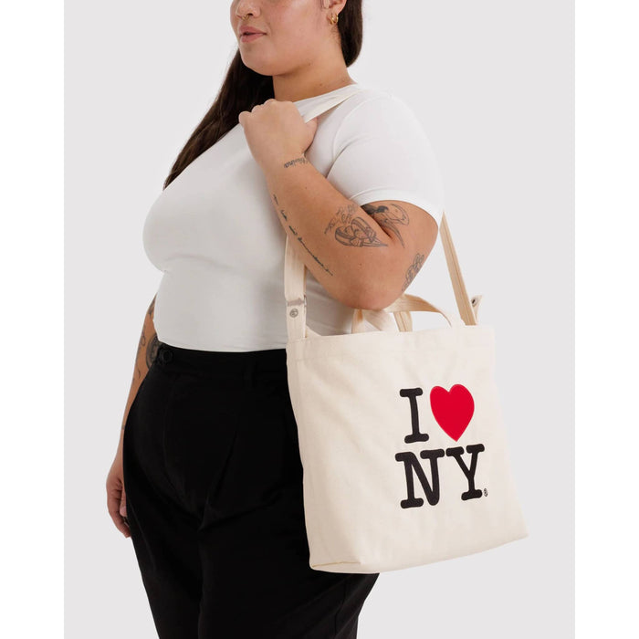 Person holding a tote bag with 'I Love NY' design on a white background.