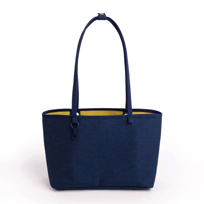 A navy blue fabric tote bag with a bright yellow interior lining, featuring two shoulder straps, shown against a plain white background.