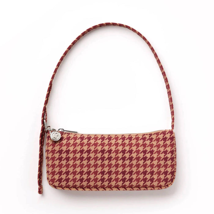 A small rectangular houndstooth shoulder bag in shades of red and tan with matching strap and a silver zipper pull with a circular logo charm, set against a plain white background.