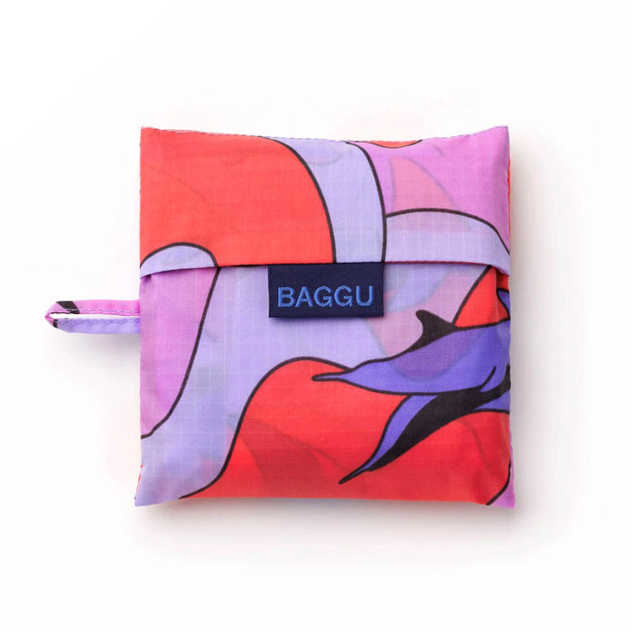 Baggu reusable shopping bag with a colorful dolphin design in matching pouch, on a white background.