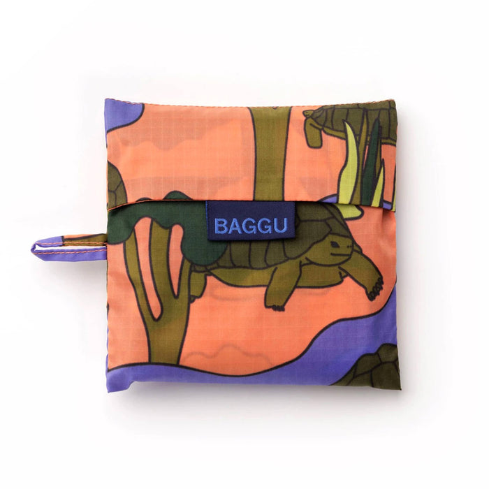 Baggu reusable shopping bag with a colorful turtle design in a matching pouch, on a white background.