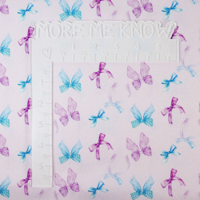 This printed WPC-Lite consists of a variety of styled bows in blue, turquoise, purple, and magenta. This photo shows a white L shaped ruler for scale.