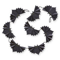 Black bat-shaped paper garland arranged in a circular pattern on a white background.