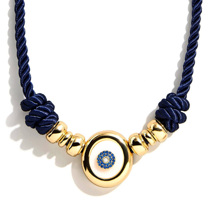 Necklace with navy blue cord and gold beads with an evil eye charm, detail view, on a white background.