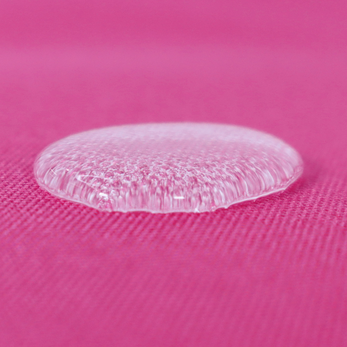 This WPC-Lite solid is in a bright pink with purple undertones. This photo shows a water drop on the fabric.