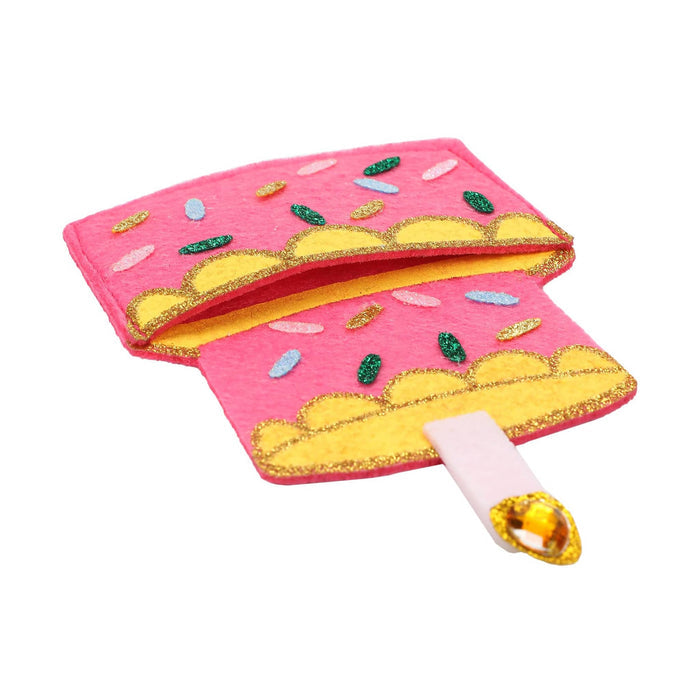A pink and yellow felt gift card holder that looks like a birthday cake, shown lying down on a plain white background.