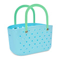 Light blue perforated basket with green handles, front angle view, on a white background.