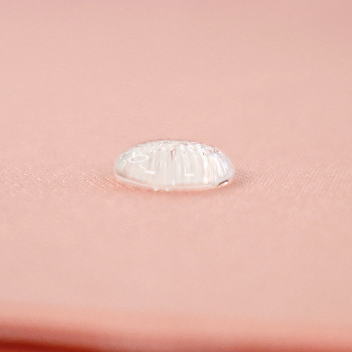 This WPC-Lite solid is in a pinky-peach shade. This photo shows a water drop on the fabric.