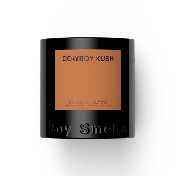 Boy Smells Cowboy Kush scented 9 ounce Classics candle in black glass vessel with dark orange label, front view.