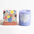 Brooklyn Candle Studio Flowers for Mama scented candle in a periwinkle vessel next to a floral print gift box, on a white background.