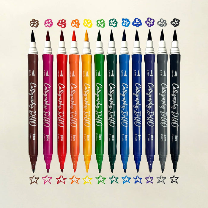12 Calligraphy Duo dual-tip markers in assorted colors are lined up vertically on a light beige background, with small flower and star color swatches above and below each marker.
