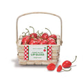 Basket of cherry-shaped lip gloss containers with a label on a white background.