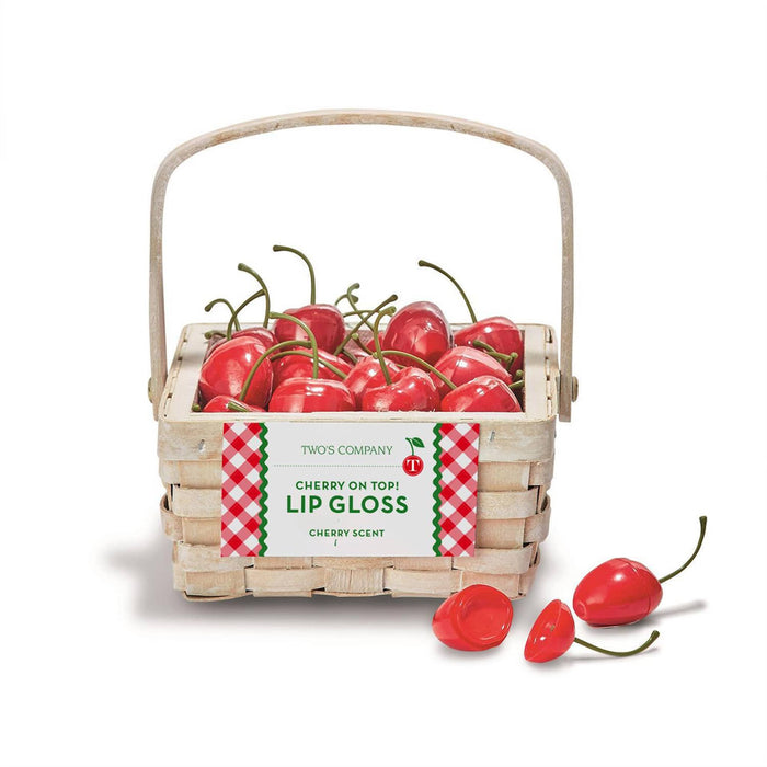 Basket of cherry-shaped lip gloss containers with a label on a white background.