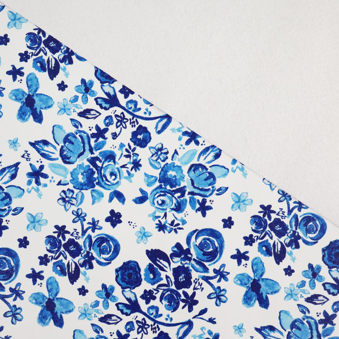 This floral print is in shades of blue with a white background.