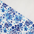 This floral print is in shades of blue with a white background.