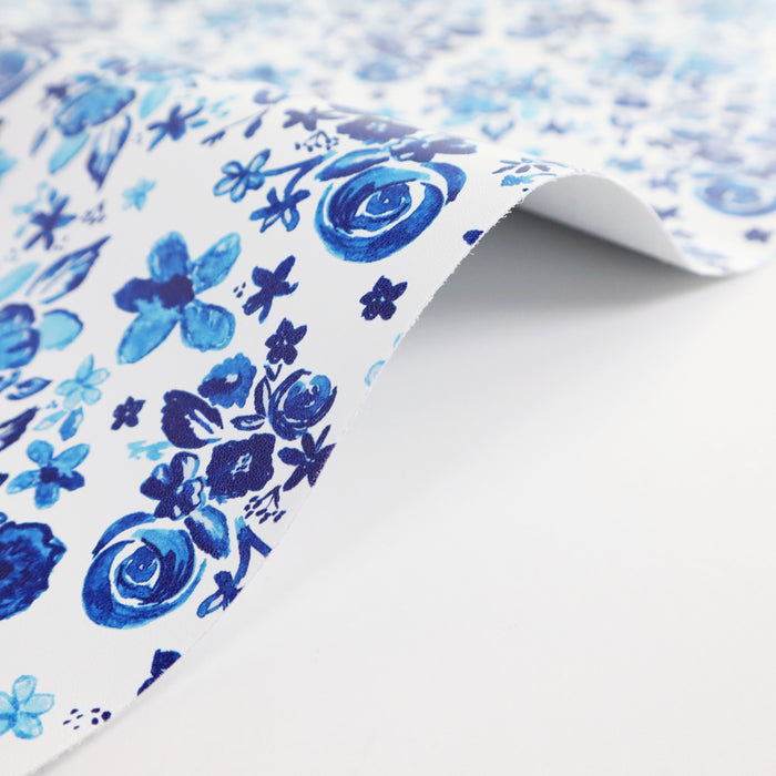 This floral print is in shades of blue with a white background.