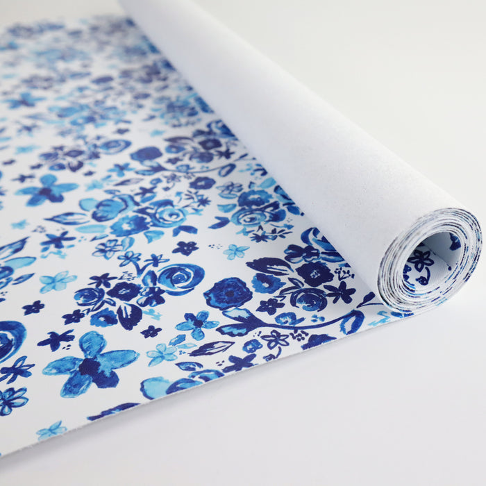 This floral print is in shades of blue with a white background. This photo shows the vinyl rolled up.