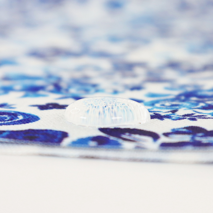 This printed WPC-Lite is of a variety of blue flowers on a white background. This photo shows a water drop on the fabric.