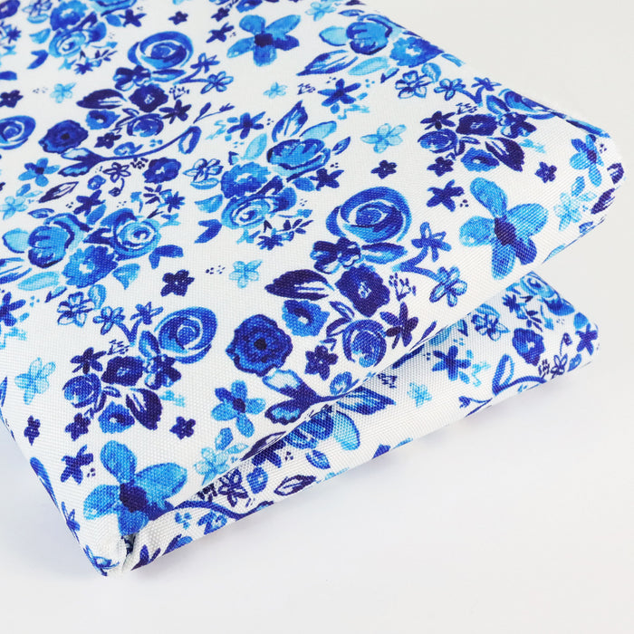 This printed WPC-Lite is of a variety of blue flowers on a white background. This photo shows the fabric folded.