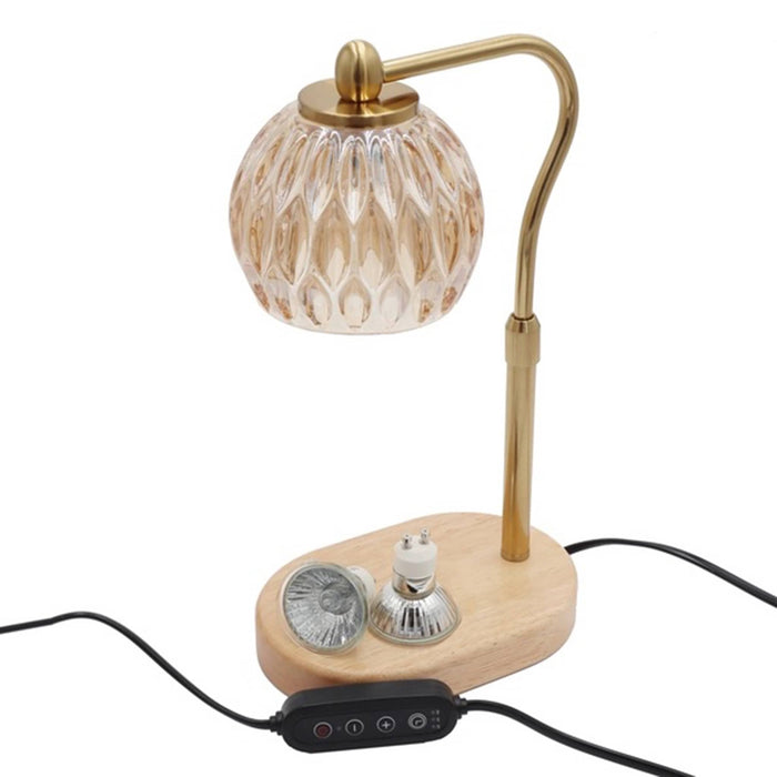 Candle warmer table lamp with crystal amber glass shade, adjustable gold stem, and wooden base, shown with controller and two halogen bulbs, on a white background.