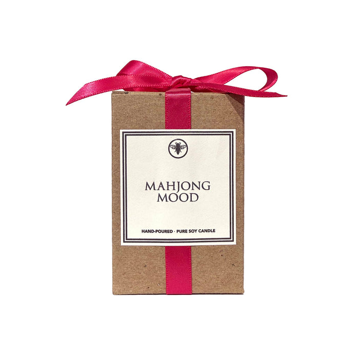 Ella B Candles scented candle in kraft box with a hot pink satin bow and "mahjong mood" on the label, on a white background.