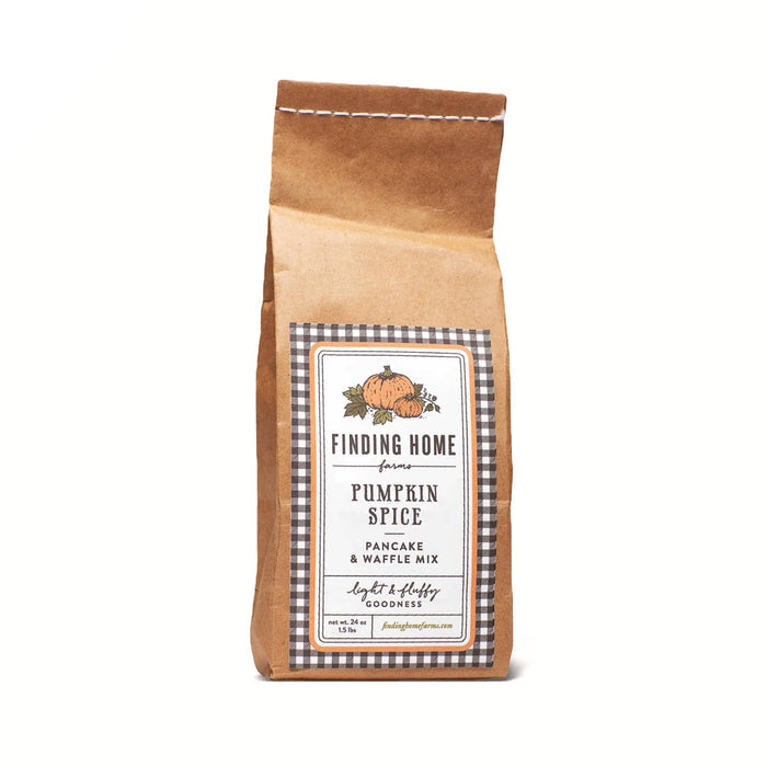 A brown kraft paper bag of Finding Home Farms Pumpkin Spice Pancake & Waffle Mix, featuring a central white label with a black-and-white gingham border and an illustration of a pumpkin.