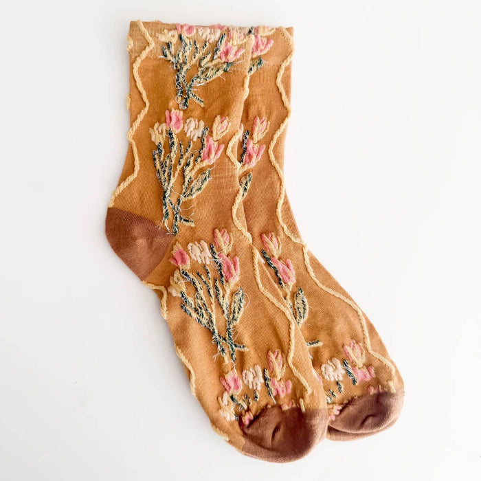 Mustard yellow socks with pink floral bouquet embroidery and a brown heel, toe, and sole, displayed on a clean white background.