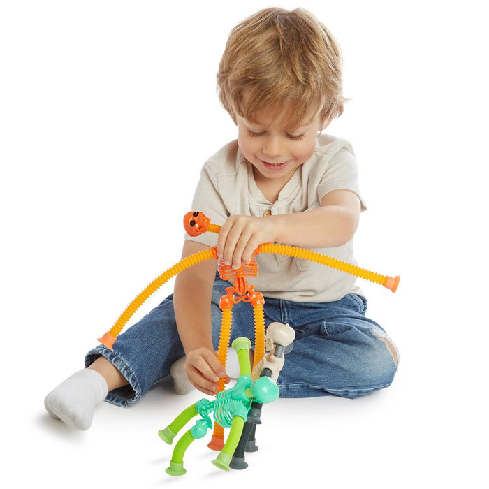 Child playing with colorful skeleton toys on a white background.