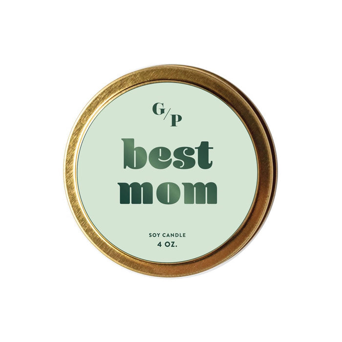 Candle in a gold tin lid with green label and 'best mom' text on a white background.