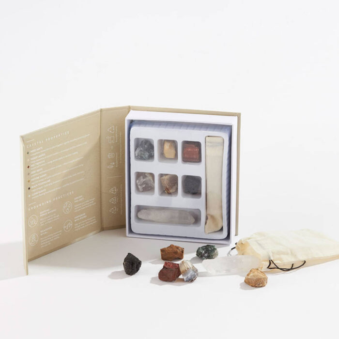 Set of stones and crystals in front and in open book box packaging, on a white background.