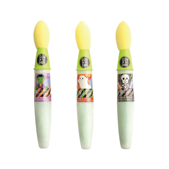 Three sponge brushes lined up horizontally on a white background. Each sponge has a bright yellow top, a lime green collar, and a white handle with a colorful Halloween-themed label featuring a zombie, a ghost, and a skull.