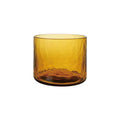 A hammered amber glass tumbler on a white background.