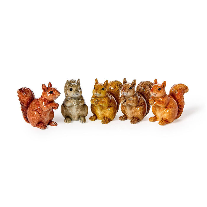 Five small decorative squirrel figurines in different earthy tones, arranged in a row on a plain white background.