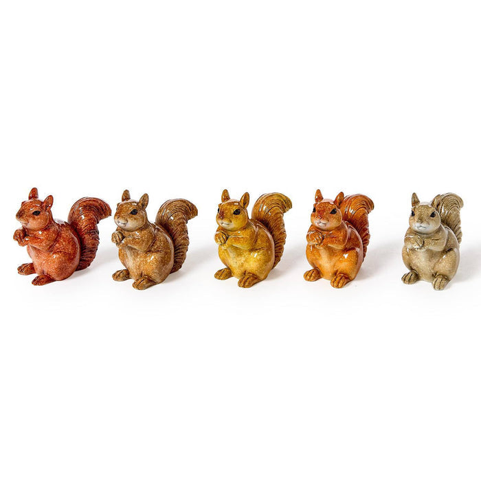 Six small squirrel figurines in different warm tones, arranged in a row, front angle view, on a plain white background.
