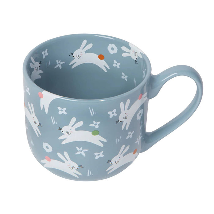 Blue mug with rabbit pattern on a white background.