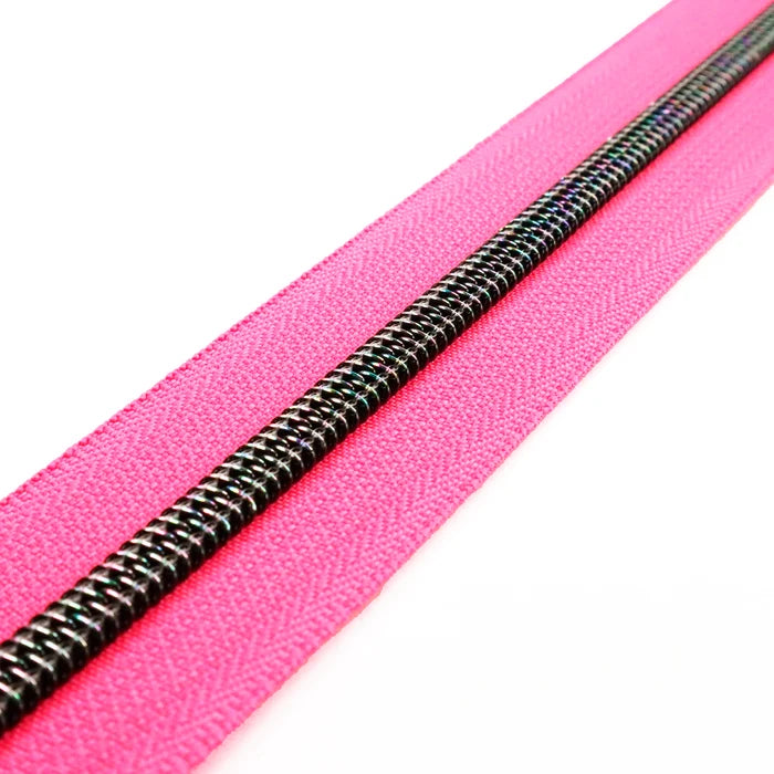 A very bright and fluorescent hot pink zipper tape with midnight rainbow coil teeth.