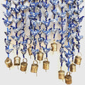 indika prosperity hen strands with blue and white small hens crafted from fabric scraps strung with blue glass beads in between and a hand formed bronze bell at the bottom.