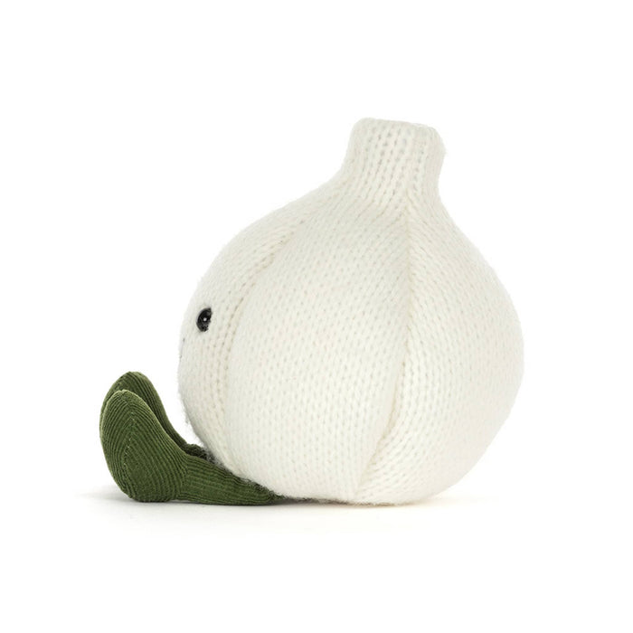 A knitted garlic plush toy in off-white with olive green corduroy feet and a simple embroidered smiley face, side view, shown on a clean white background.