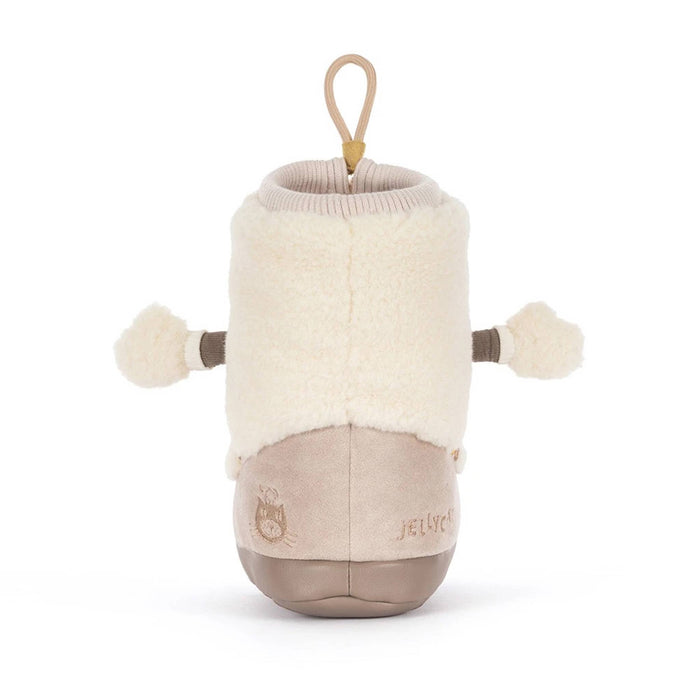 A snow boot-shaped plush toy with a cream sherpa upper, beige corduroy-like lower section, and a tan hanging loop at the top, back view, shown on a plain white background.
