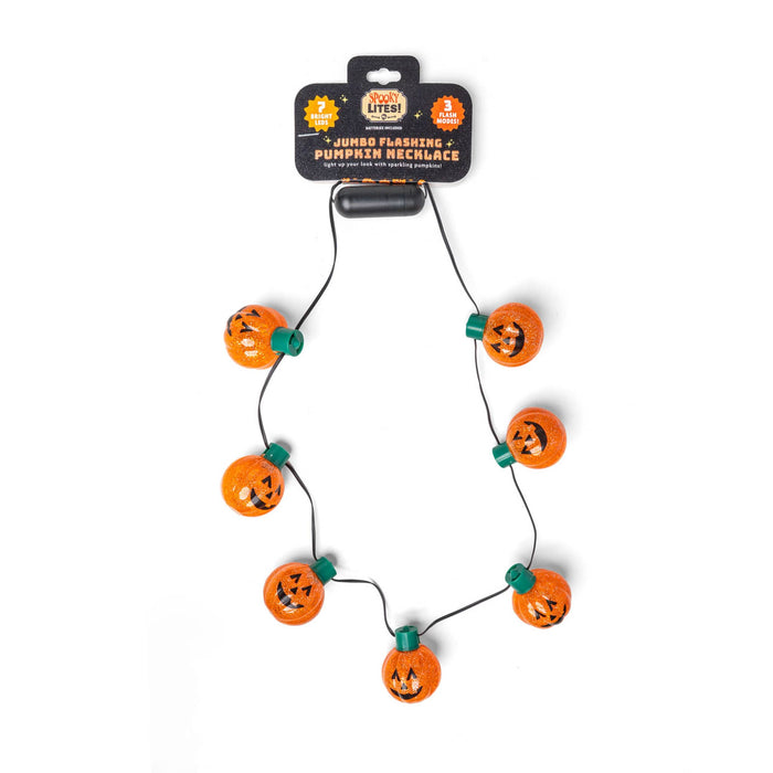 A Halloween-themed jumbo flashing pumpkin necklace on a black cord, featuring multiple orange glitter pumpkins with black jack-o'-lantern faces and green accents, attached to a black retail header card.