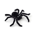 A flocked black spider decoration with realistic textured legs and small white eyes, photographed on a clean white background.