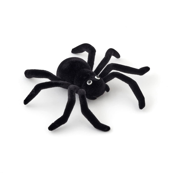 A flocked black spider decoration with realistic textured legs and small white eyes, photographed on a clean white background.