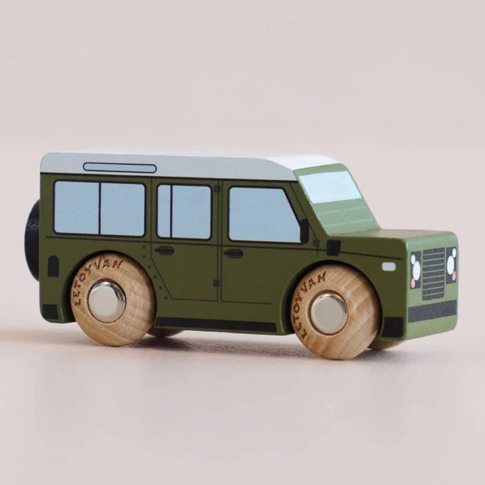 Green toy SUV with wooden wheels, front angle view, on a beige background.